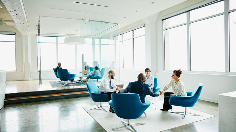 Professionals shaking hands inside the conference room
