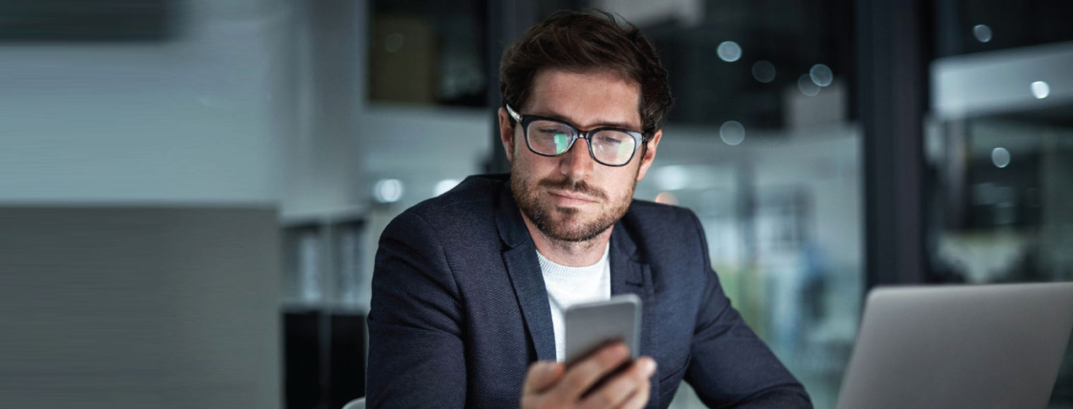 Man with glasses looking at the phone Man with glasses looking at the phone