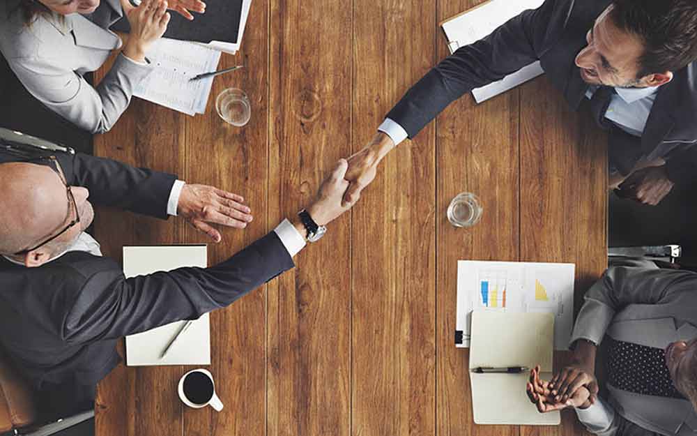 Professionals shaking hands across the table