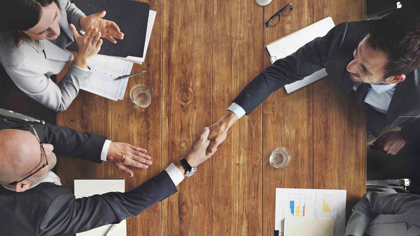 Business professionals shaking hand over the table Business professionals shaking hand over the table