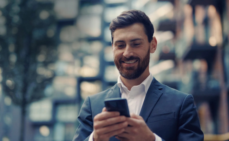 Man smiling at his smartphone